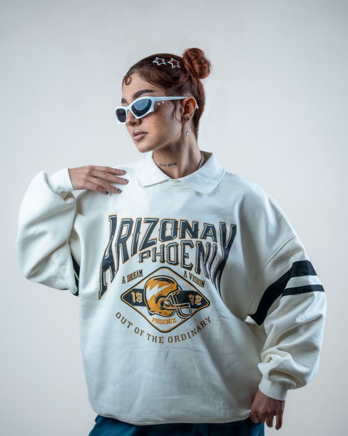 Stylish woman wearing sunglasses and an Arizona sweatshirt posing confidently.